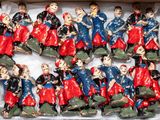 de nombreuses figurines représentant des personnes, rangées dans une boîte posée sur une table