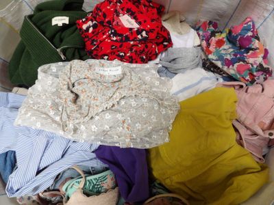 un panier rempli de vêtements posé sur le sol