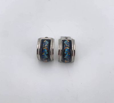 a pair of blue and silver earrings on a white surface