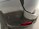 a car that has been dented and is parked in a lot
