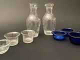 a group of glass vases and cups sitting on a table