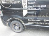 a black van that has a measuring scale on the side of it