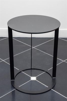a black table with a glass top sitting on a tiled floor