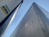 looking up at the side of a semi truck with a blue sky in the background