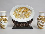 three vases and a plate sitting on a table