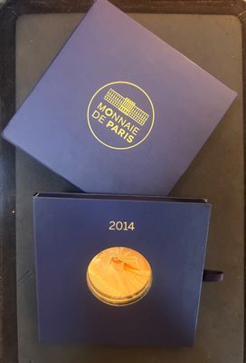 la boîte est ouverte sur un plateau dans lequel se trouve une pièce d'or