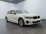 a white bmw 3 series sedan parked in a showroom