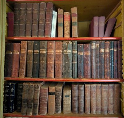de nombreux livres anciens rangés sur une étagère d'une bibliothèque