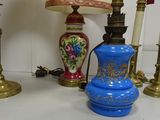 un vase bleu posé sur une table, à côté de deux bougies dorées