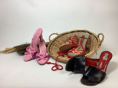 plusieurs paires de chaussures et un panier posés sur une surface blanche