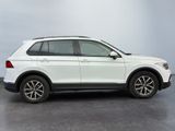 the white volkswagen suv is parked in a room with gray walls