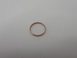 a gold wedding ring on a white surface