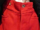 a mannequin wearing a pair of red pants and a black jacket