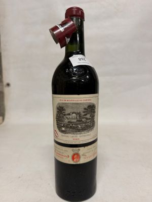 une vieille bouteille de vin posée sur une table blanche