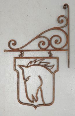 une plaque métallique représentant un cheval, accrochée au mur
