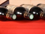 several bottles of wine are lined up on a red cloth