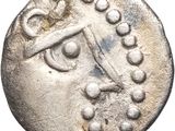 a silver coin with an image of a face on it