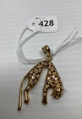 un gros plan d'un pendentif en or orné d'une girafe