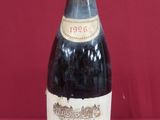 bottle of red wine sitting on a red surface with a red background