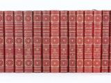 Les livres rouges sont alignés contre un mur blanc.