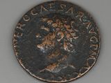 une vieille pièce de monnaie sur laquelle figure un homme assis sur une table