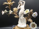 une figurine représentant une femme tenant un vase posé sur une table