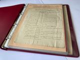 un classeur rouge sur lequel sont inscrits des mots, posé sur une table