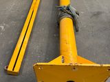 a yellow pole sitting on the ground next to a pile of metal