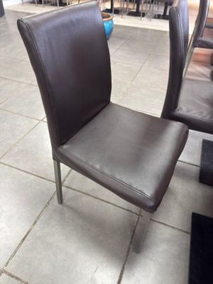 un fauteuil en cuir marron posé à même le sol