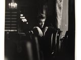 black and white photograph of a man sitting at a table