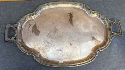 un plateau en argent muni d'une poignée, posé sur une table