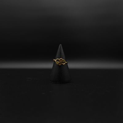 une bague en or sur une surface noire, avec un fond noir