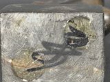 a close up of a piece of metal with a hammer in it