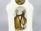 a figurine of two people in a small clock tower
