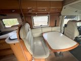 an image of the inside of a camper with a table and chairs