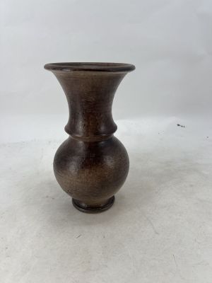 a brown vase that is sitting on a white surface
