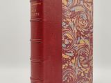 un livre rouge orné de motifs dorés et bleus