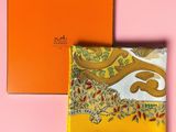 an orange box with a yellow paisley print on it next to a yellow handkerchief