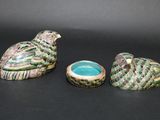 three pieces of pottery sitting on top of a table next to each other