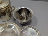 several silver plated dishes and cups on a table