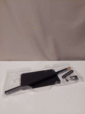 Le contenu d'un cahier noir, d'un stylo et d'un crayon est disposé sur une surface blanche.
