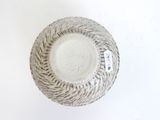 a white bowl with a rope around it on a white surface