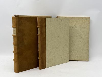 two old books sitting next to each other on a white surface