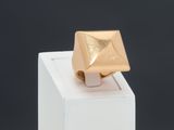 an image of a gold ring sitting on top of a white box