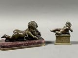paire de figurines en bronze représentant un garçon et une fille allongés sur une boîte