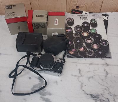 un appareil photo et une boîte d'objectifs posés sur une table