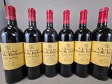 six bottles of red wine lined up in a row on a table