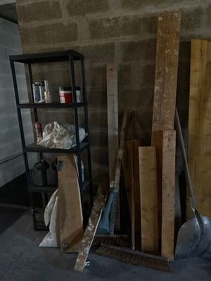 Plusieurs morceaux de bois sont empilés sur une étagère dans une pièce