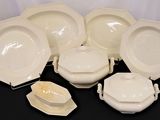 a lot of white plates and bowls on the table
