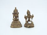 pair of brass figurines of hindu deities on a white background